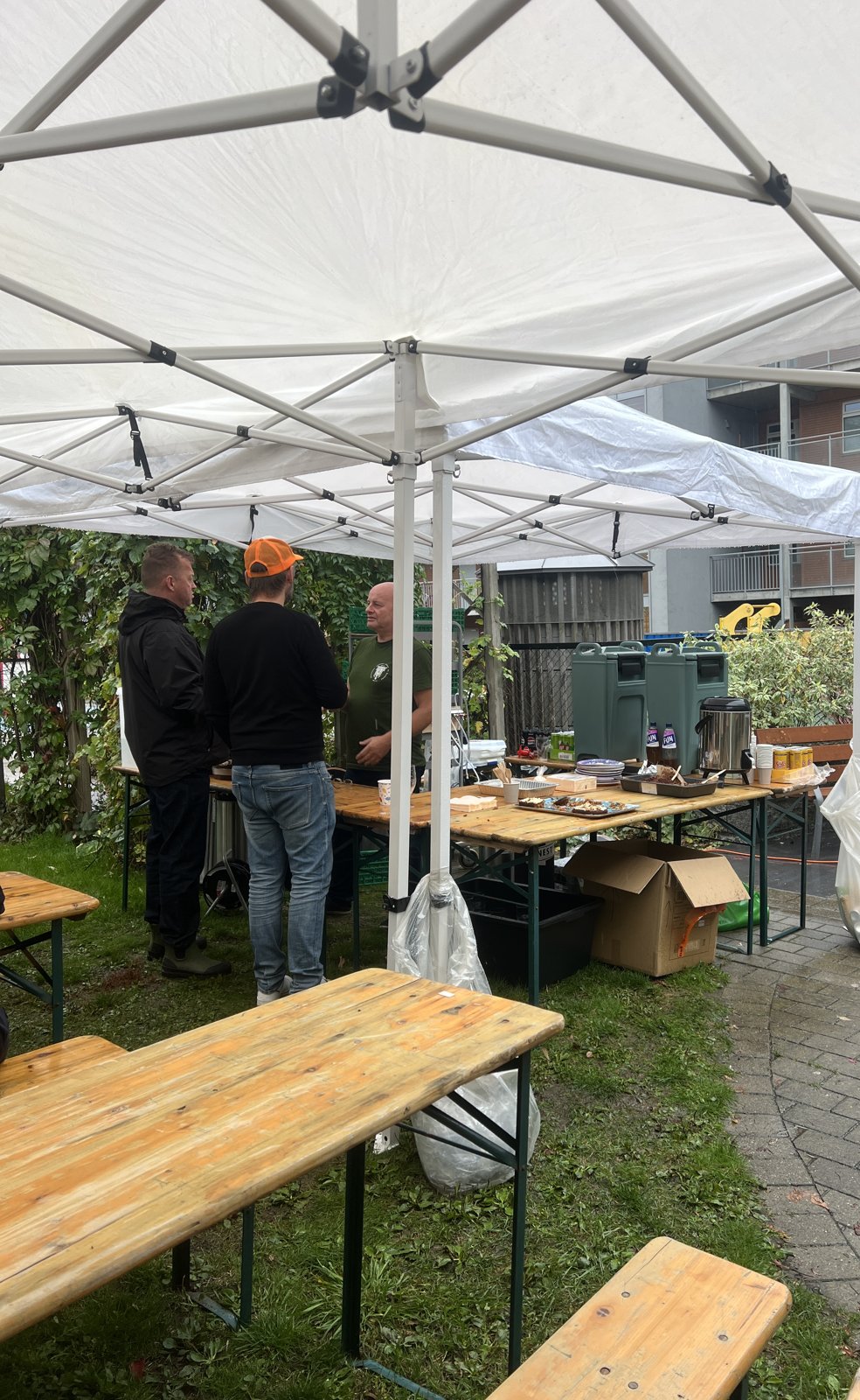 Partytelt med festivalbord og benker på en plen