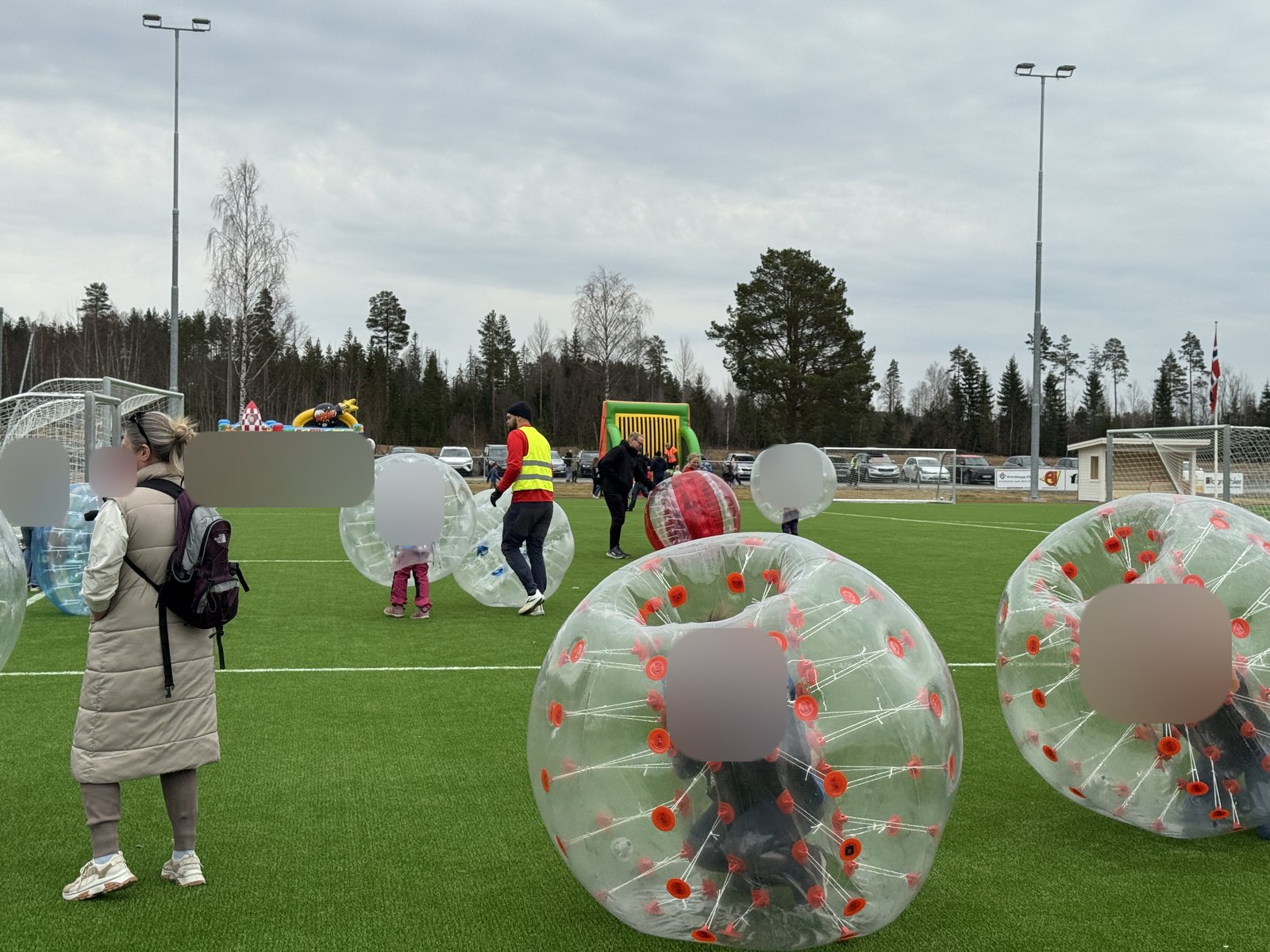 Boblefotball på kunstgressbane, med hoppeslott i bakgrunnen