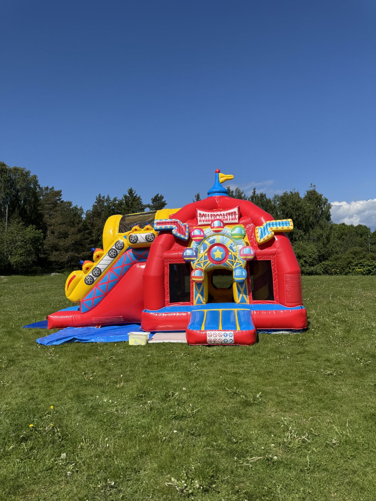 Hoppeslott Super Rollercoaster med sklie på en plen