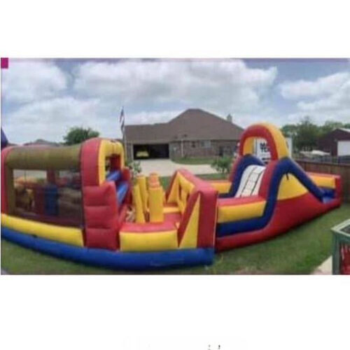 Colorful inflatable bounce slide on a grassy yard beside a brick house under a cloudy sky