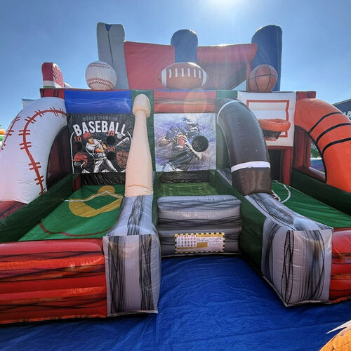 Colorful inflatable bounce slide on a grassy yard beside a brick house under a cloudy sky